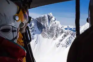 Heli skiing guest view from back seat of helicopter